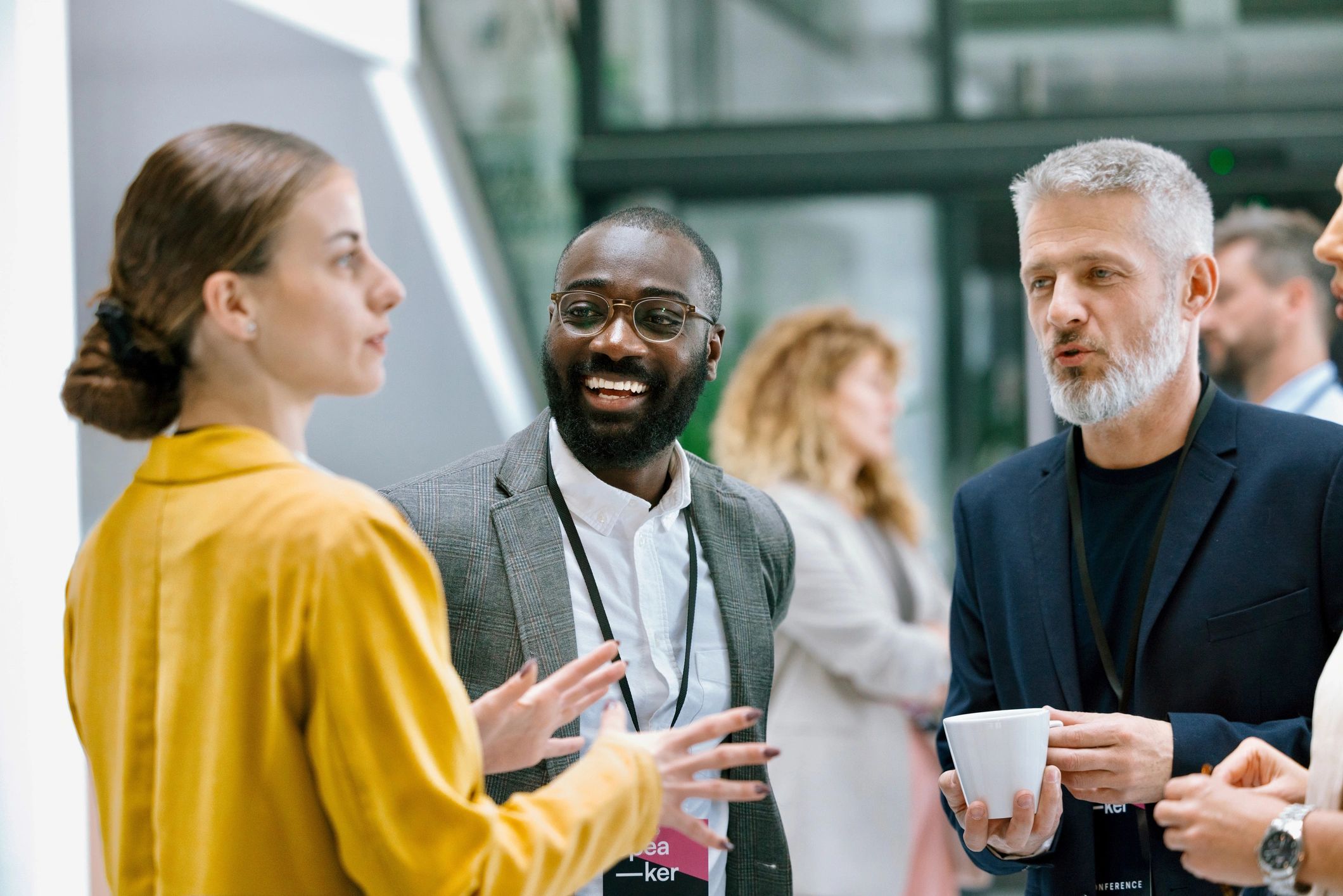 Colleagues chatting and smiling during a conference break